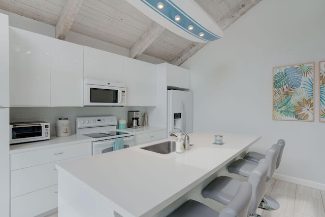 kitchen featuring white cabinets, white appliances, sink, and a kitchen island with sink