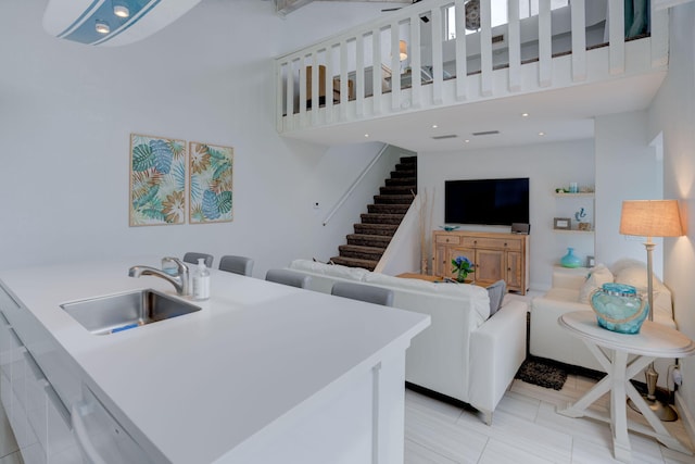 living room featuring a towering ceiling and sink