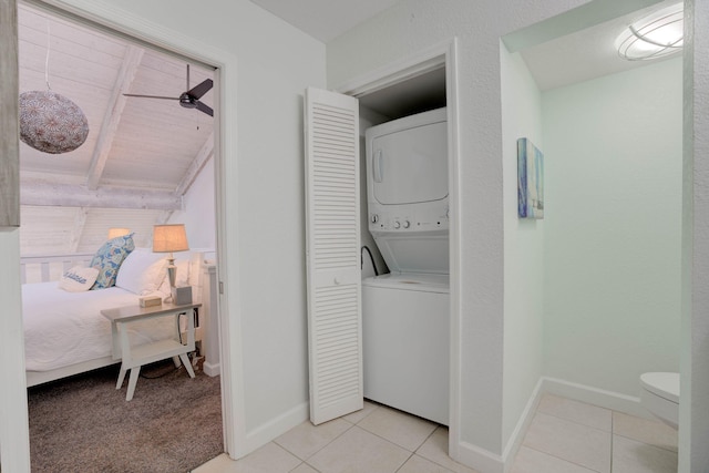 laundry room with stacked washer / drying machine, ceiling fan, and light tile patterned floors