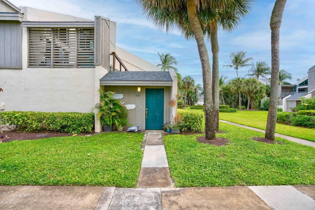 property entrance with a lawn