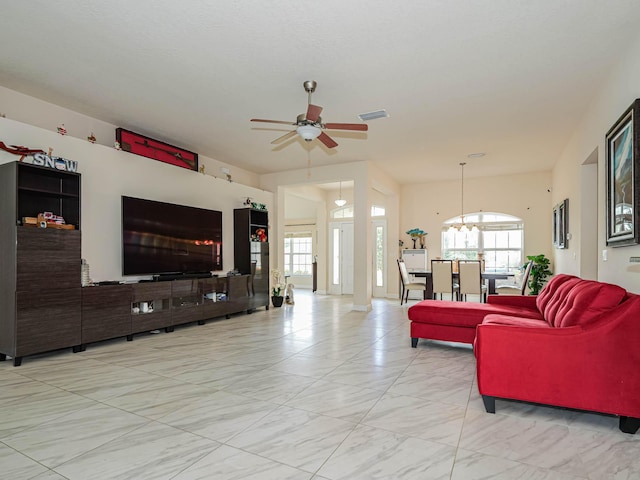 living room with ceiling fan with notable chandelier and a healthy amount of sunlight