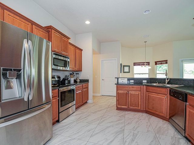 kitchen featuring sink, stainless steel appliances, decorative light fixtures, and an inviting chandelier