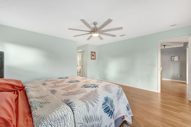 bedroom with a closet, light hardwood / wood-style flooring, and ceiling fan