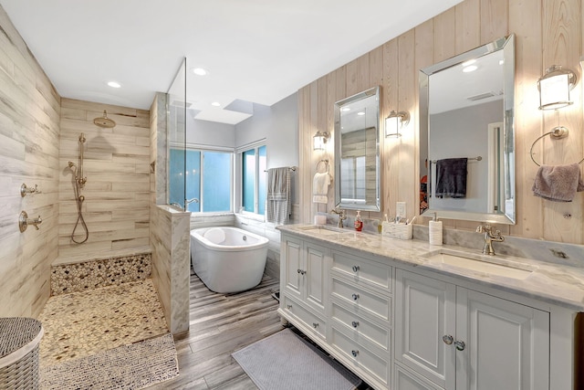 bathroom with vanity, wood walls, wood-type flooring, and separate shower and tub