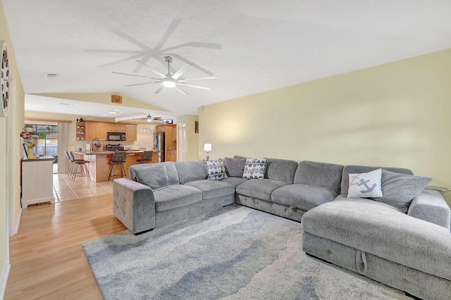 living room featuring light hardwood / wood-style floors, lofted ceiling, and sink