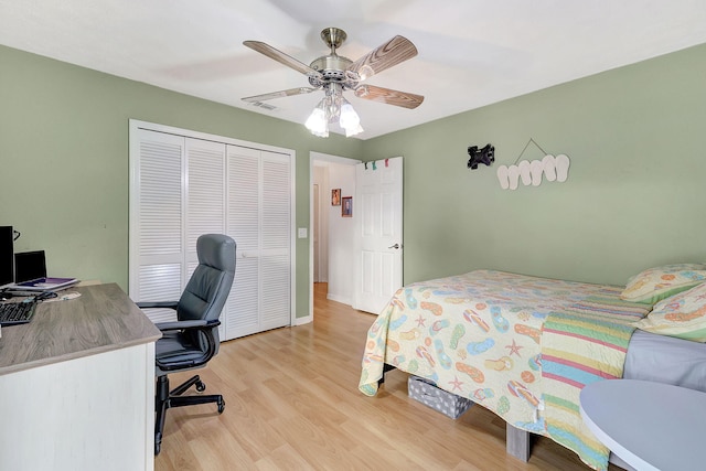 bedroom featuring ceiling fan, a closet, and light wood-type flooring