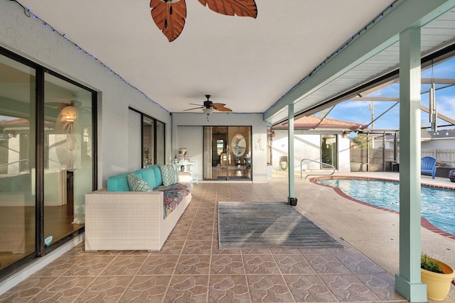 view of pool featuring a patio area, ceiling fan, outdoor lounge area, and glass enclosure