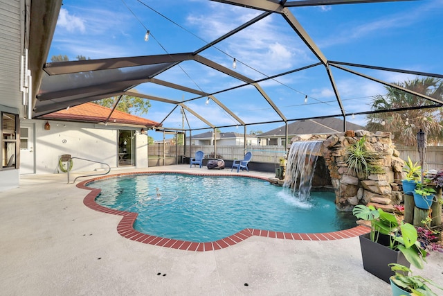 view of swimming pool featuring glass enclosure, pool water feature, and a patio