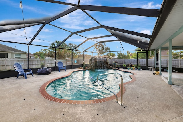 view of pool featuring glass enclosure, pool water feature, and a patio