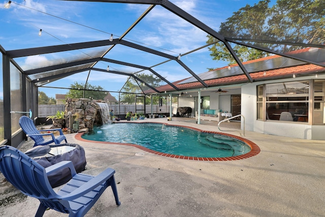 view of swimming pool featuring a lanai, pool water feature, ceiling fan, and a patio area