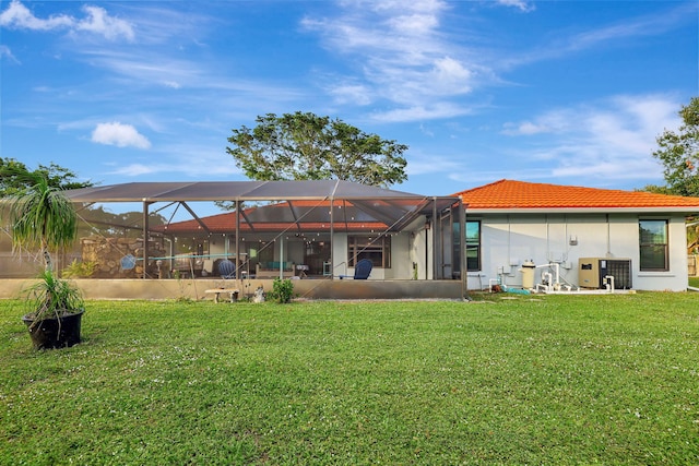 back of property featuring glass enclosure, a yard, and cooling unit