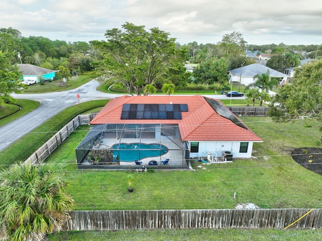 rear view of property with glass enclosure and solar panels