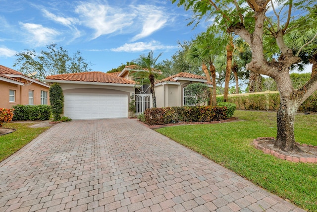 mediterranean / spanish home featuring a front yard and a garage