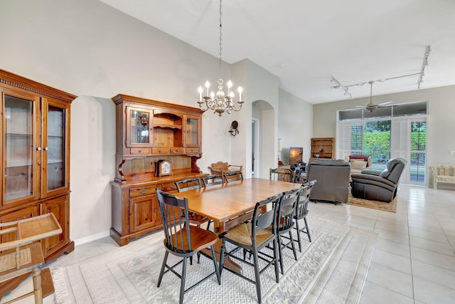 dining area with rail lighting, light tile patterned flooring, and ceiling fan with notable chandelier