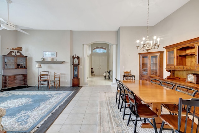 dining area featuring light tile patterned floors and ceiling fan with notable chandelier