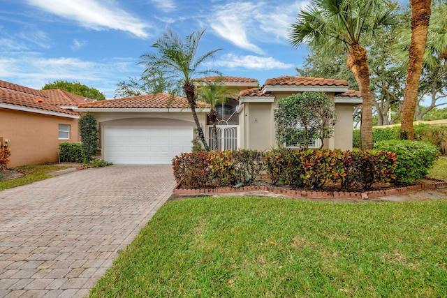 mediterranean / spanish-style house featuring a front lawn and a garage