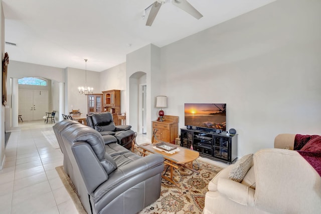 tiled living room with ceiling fan with notable chandelier