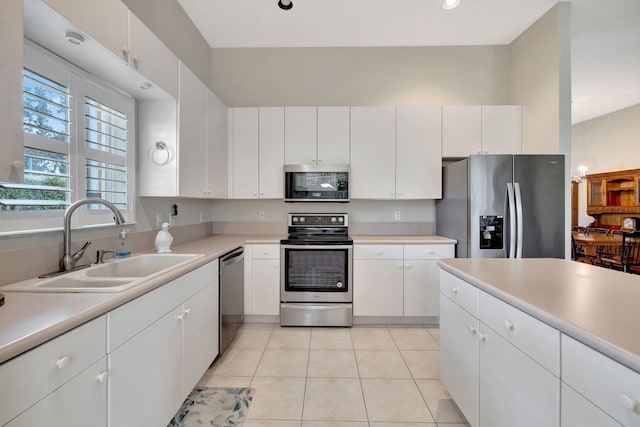 kitchen with white cabinets, sink, light tile patterned floors, and stainless steel appliances