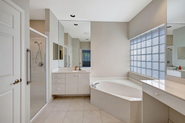 bathroom with tile patterned floors, vanity, and shower with separate bathtub