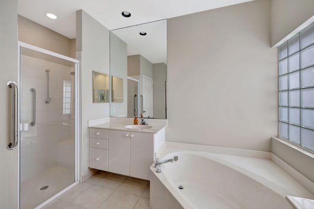 bathroom featuring tile patterned floors, vanity, and shower with separate bathtub