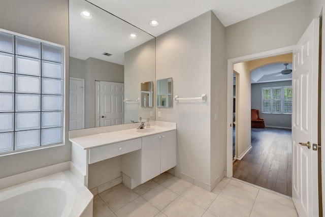 bathroom featuring a bath, vanity, hardwood / wood-style flooring, and ceiling fan