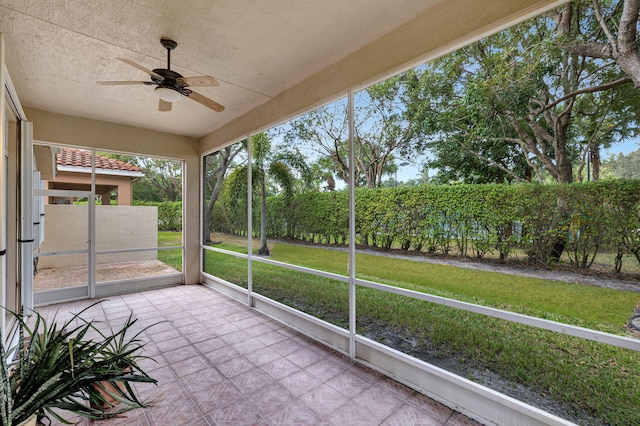 unfurnished sunroom featuring ceiling fan