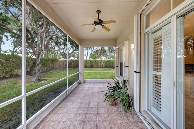 unfurnished sunroom featuring ceiling fan