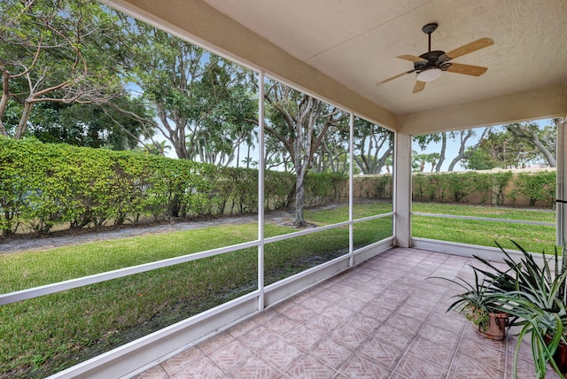 unfurnished sunroom with ceiling fan