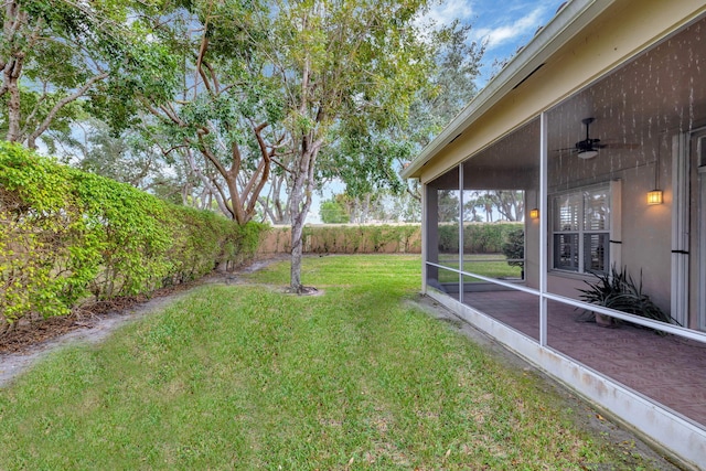 view of yard with a sunroom and ceiling fan