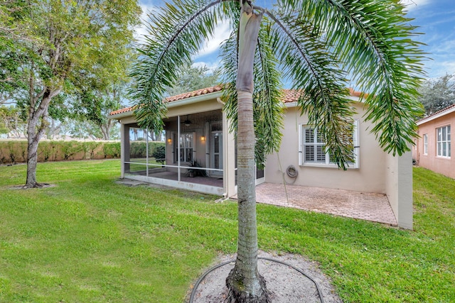 back of house with a patio area, a sunroom, a yard, and ceiling fan