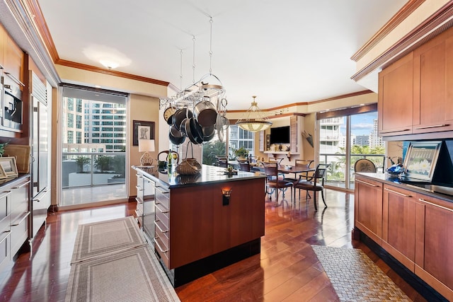 kitchen featuring dark hardwood / wood-style flooring, a kitchen island, hanging light fixtures, and ornamental molding