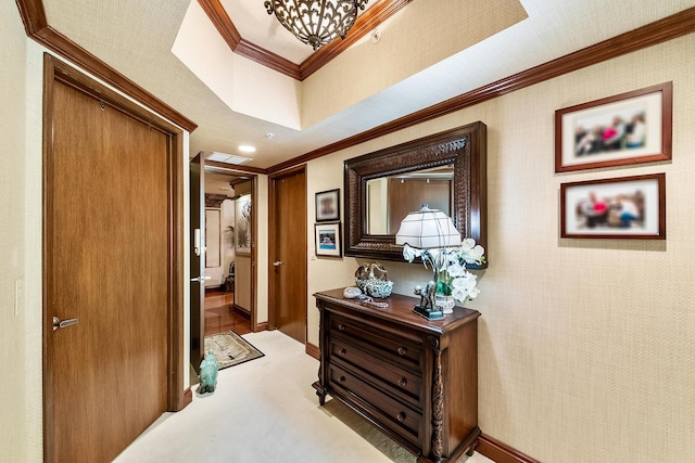 corridor with a raised ceiling and crown molding