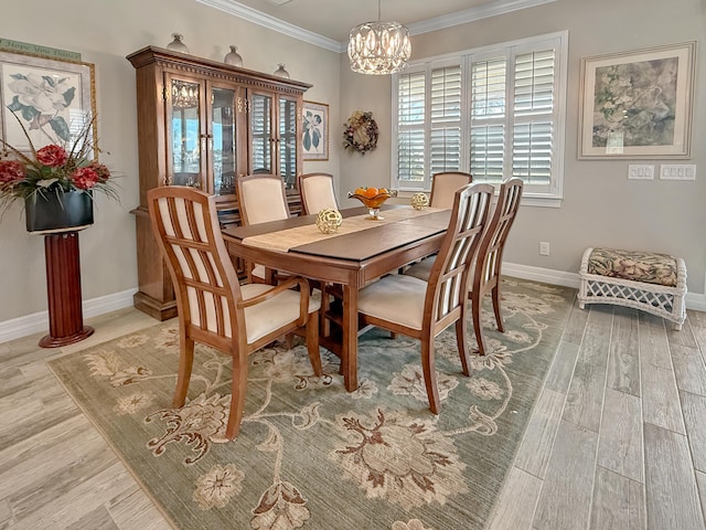 dining room featuring an inviting chandelier, ornamental molding, and light hardwood / wood-style floors