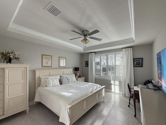 bedroom with ceiling fan, tile patterned floors, and a tray ceiling