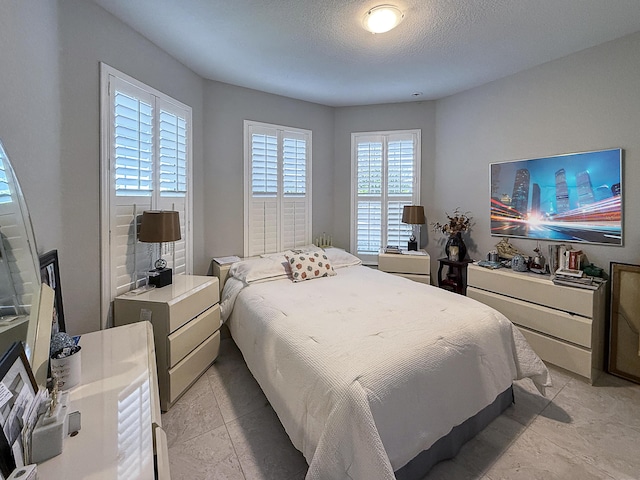 bedroom with a textured ceiling and light tile patterned flooring