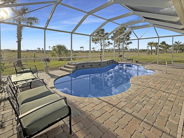 view of pool with a lanai, a patio, and a rural view