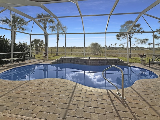 view of pool with a patio, a lanai, and a rural view