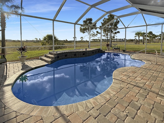 view of swimming pool featuring a lanai, a rural view, and a patio area