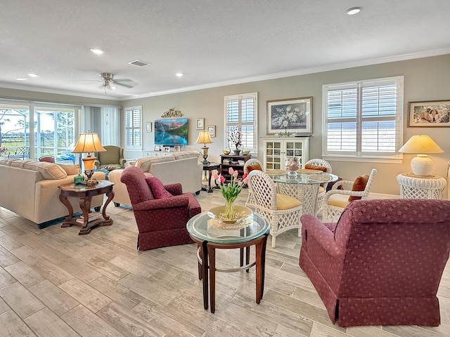 living room featuring crown molding, plenty of natural light, and light hardwood / wood-style floors