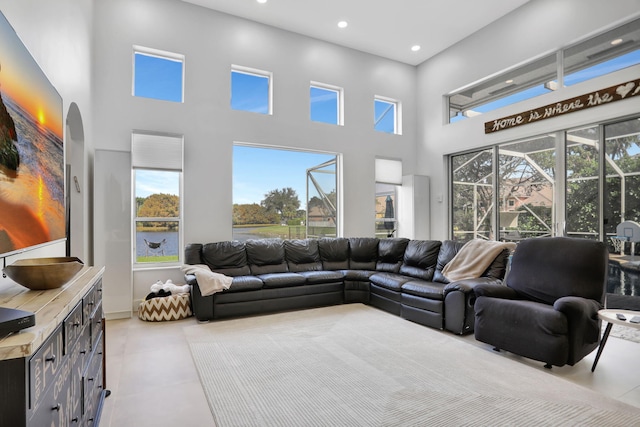 living room featuring plenty of natural light, light tile patterned flooring, and a high ceiling