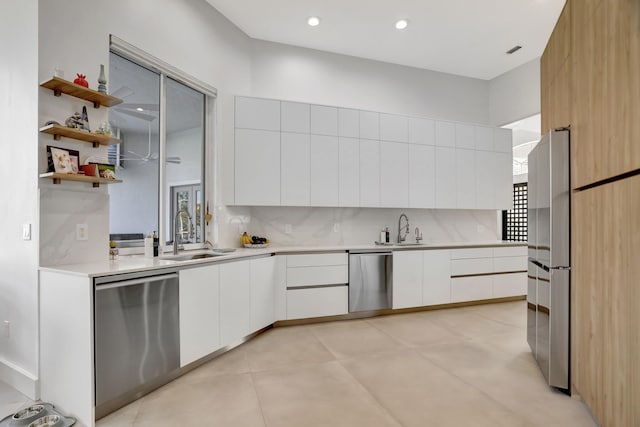 kitchen featuring white cabinets, decorative backsplash, sink, and stainless steel appliances