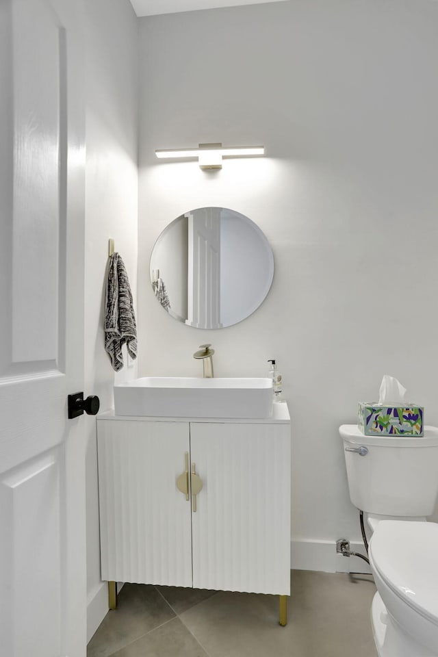 bathroom with tile patterned flooring, vanity, and toilet