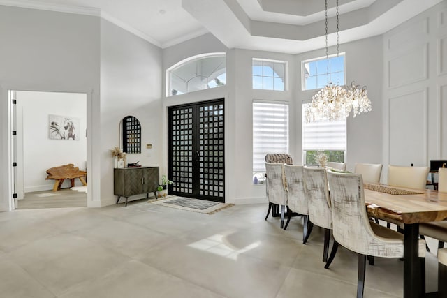 dining room with plenty of natural light, ornamental molding, a high ceiling, and a notable chandelier