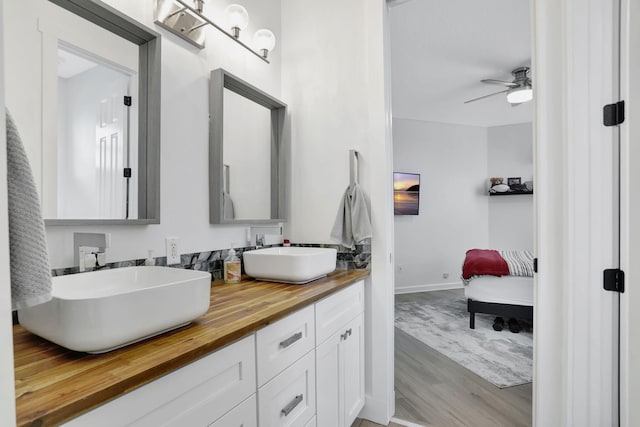 bathroom featuring ceiling fan, vanity, and wood-type flooring