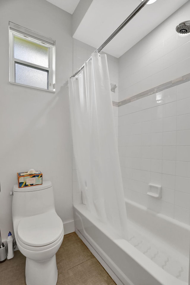 bathroom with tile patterned flooring, shower / bath combo, and toilet