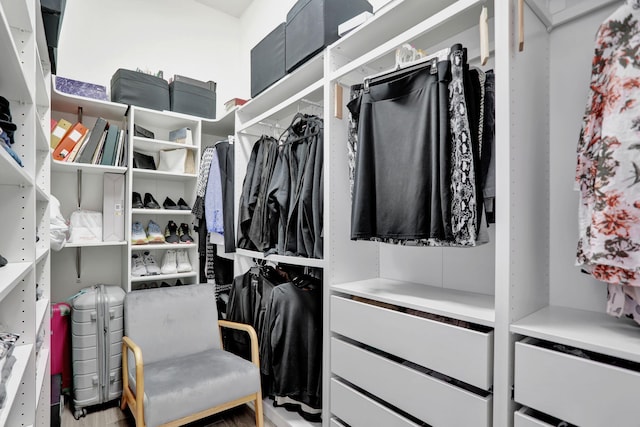 walk in closet with light hardwood / wood-style floors