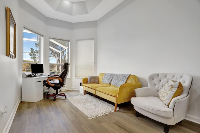 home office with hardwood / wood-style floors and a towering ceiling