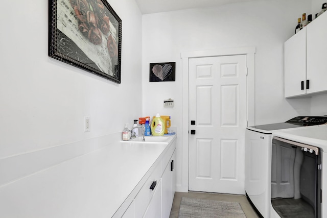 laundry room with cabinets, sink, and washing machine and dryer