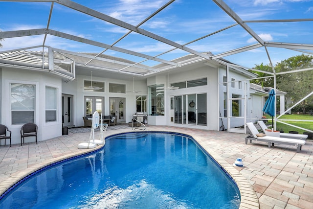 view of pool with french doors, a patio, ceiling fan, and a lanai