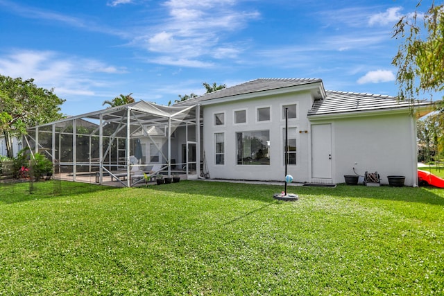 rear view of property featuring glass enclosure and a lawn